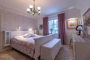 een slaapkamer met een wit bed en een kroonluchter bij JON832-Mansarp-Bondstorp-Bjoerksaeter-1 in Bondstorp