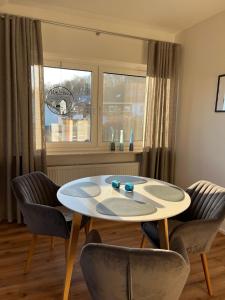 een tafel en stoelen in een kamer met een raam bij Ferienwohnung Waldzauber in Naumburg