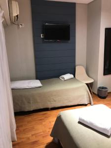 a room with two beds and a flat screen tv at Viasui Hotel in Buenos Aires +51 photos