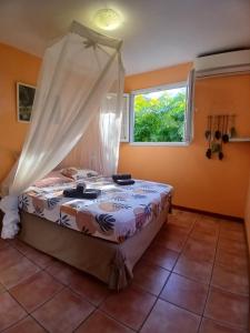 een bed in een kamer met een raam bij La Kaz Kako in Sainte-Rose +26 foto's