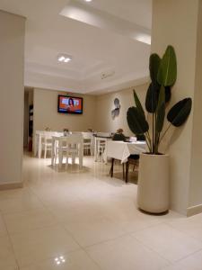 a dining room with tables and a potted plant at Viasui Hotel in Buenos Aires