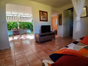 een woonkamer met een bed en een televisie bij La Kaz Kako in Sainte-Rose