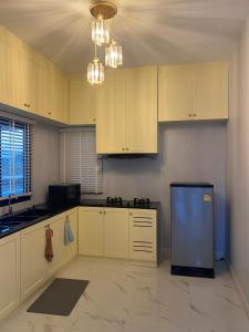 a kitchen with white cabinets and a blue refrigerator at Alayah บ้านเดี่ยวสองชั้น ธาดาดิโอเอซิส in Ban Krok Khi Nu
