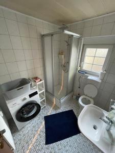 a bathroom with a washing machine and a sink at Ferienwohnung I&I in Halsenbach +16 photos