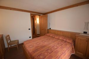 una camera da letto con un letto e una sedia di Bicamere Piazza Carli ad Asiago