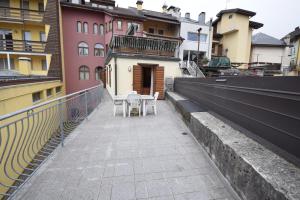 un balcone con tavolo e sedie su un edificio di Bicamere Piazza Carli ad Asiago