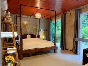 una camera da letto con un letto a baldacchino in una stanza di วีรพัชนารา a Ban Musoe