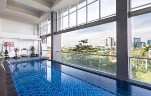 a swimming pool with a view of a building at Fairview Hotel by ARTOTEL in Jakarta