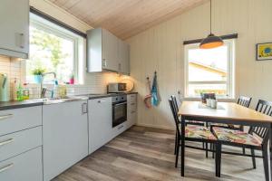 een keuken met witte kasten en een tafel met stoelen bij DAL956-Dals-Langed-Sandviksudden-5 in Långbron