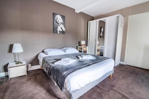 a bedroom with a large bed and a mirror at Le Vincennes, simple et atypique ! in Cholet
