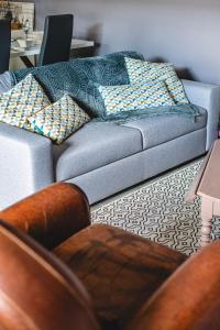 a living room with a couch with pillows on it at Le Vincennes, simple et atypique ! in Cholet +7 photos