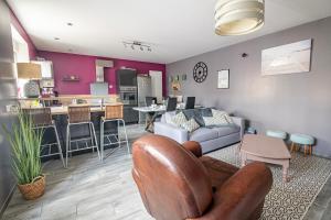 a living room with a couch and a kitchen at Le Vincennes, simple et atypique ! in Cholet