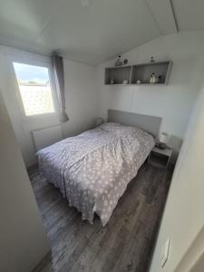 a small bedroom with a bed and a window at Dans le vent in Middelkerke