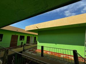 a green building with a fence next to it at Hotel La Mata in La Mata