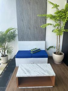 a blue bench in a room with potted plants at Villa Daisy Private Pool in Tanah Lot