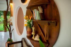 a mirror with a shelf with books and a plant at Ceylon Marley Villa in Talawa