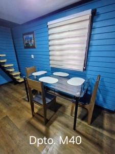 tavolo da pranzo con sedie e parete blu di Wildepartamentos Valdivia TM a Valdivia