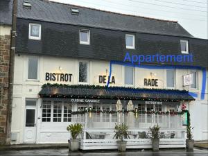 un magasin devant un bâtiment présentant des décorations de Noël dans l'établissement Proximité du port de Perros Guirec, à Perros-Guirec
