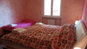 een slaapkamer met een bed met een dekbed erop bij Happy Home Apartament in Arezzo