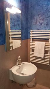 een badkamer met een witte wastafel en een spiegel bij Happy Home Apartament in Arezzo