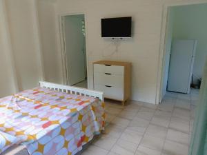 a bedroom with a bed and a tv on the wall at BRADA gites in Deshaies