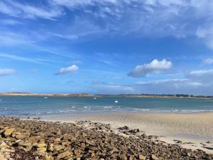 - une plage avec un tas de rochers et l'océan dans l'établissement Proximité du port de Perros Guirec, à Perros-Guirec