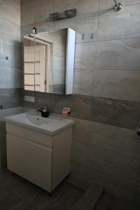 een badkamer met een wastafel en een spiegel bij Bright and cozy apartment nr. 1 in Chişinău +27 foto's