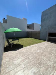 a green umbrella sitting on top of a building at Baita Di Franca in Cordoba