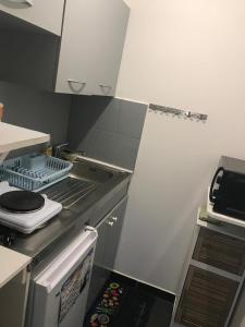 a kitchen with a sink and a stove top oven at lagon studio ermitage in Saint-Paul +7 photos