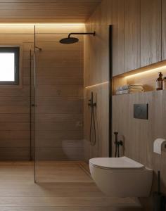 ein Badezimmer mit Toilette und Glasdusche in der Unterkunft Domki Lubikowo in Lubikowo