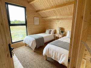 ein Schlafzimmer mit zwei Betten in einer Blockhütte in der Unterkunft Domki Lubikowo in Lubikowo