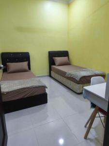zwei Betten in einem Zimmer mit grünen Wänden in der Unterkunft Dreamy Stay Penang in Butterworth