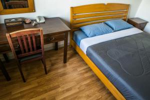 a bedroom with a bed and a desk and a chair at United Place in Bangsaen