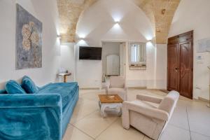 a living room with a blue couch and chairs at Volta Apartment in Mesagne +21 photos