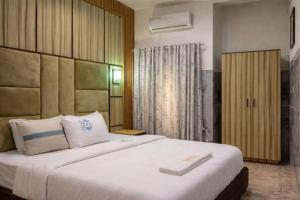 a bedroom with a large white bed in a room at Royal Modak Resort & Hotel in Ibadan +51 photos