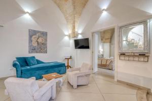 a living room with a blue couch and chairs at Volta Apartment in Mesagne