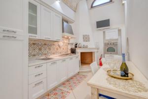a kitchen with white cabinets and a table at Volta Apartment in Mesagne
