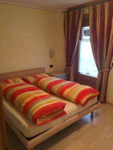 un letto con coperte colorate sopra di Martin Haus a Livigno