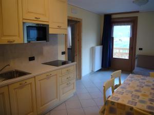 una cucina con mobili bianchi e un tavolo e una sala da pranzo di Martin Haus a Livigno