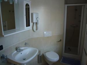 un bagno con lavandino, WC e specchio di Martin Haus a Livigno