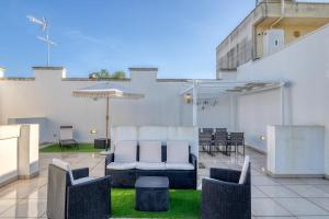 a patio with chairs and tables on a building at Volta Apartment in Mesagne
