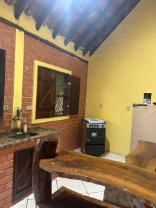 a kitchen with a stove and a wooden bench at Chalés Moinho in Carrancas +1 photo