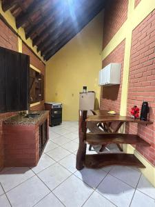 a kitchen with a wooden table and a refrigerator at Chalés Moinho in Carrancas