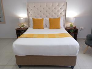 a bedroom with a large bed with yellow pillows at Travellers paradise in Palatswe