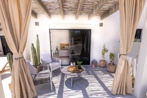 ein Wohnzimmer mit Vorhängen und einem Tisch in der Unterkunft Casa del Mar - Luxury Seaside Villa in Boca de la Vinorama
