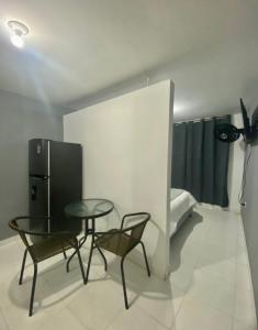 a room with a table and two chairs and a refrigerator at Apartamentos con aire acondicionado SAN LUIS in San Luis +6 photos