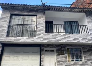 a brick house with two garage doors and a balcony at Apartamentos con aire acondicionado SAN LUIS in San Luis