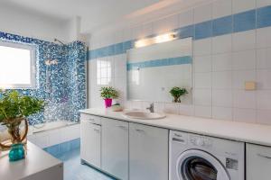 a bathroom with a washing machine and a sink at Villa Aggeliki by Villa Plus in Pírgos Psilonérou