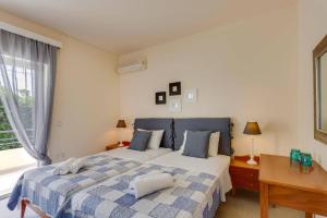 a bedroom with a bed and a desk and a window at Villa Aggeliki by Villa Plus in Pírgos Psilonérou +9 photos