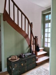 un chapeau posé sur une vieille malle à côté d'un escalier dans l'établissement Maison Huitlala, à Lavaufranche